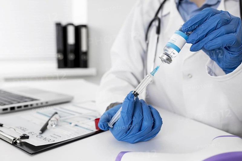Close up doctor holding medical syringe