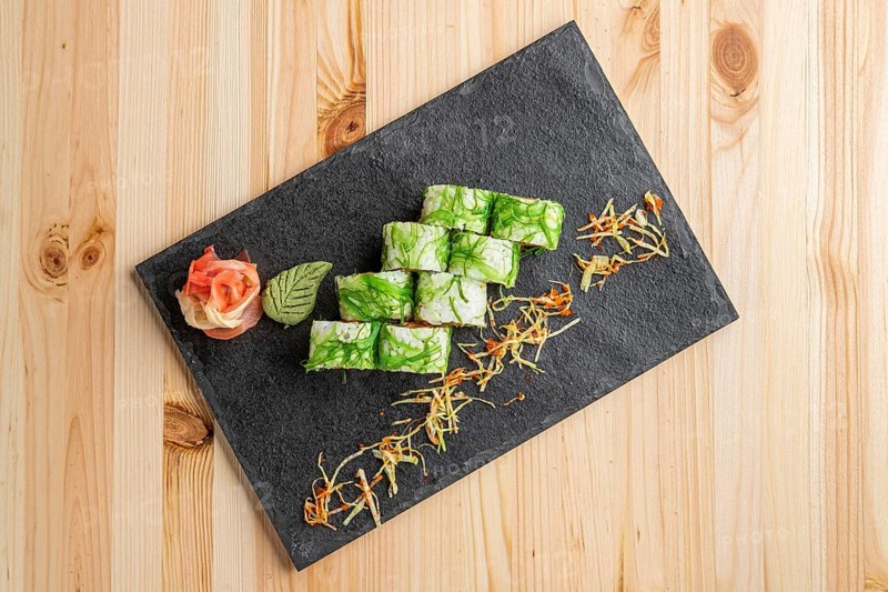 Set of rolls with wasabi and pickled ginger on stone serving board