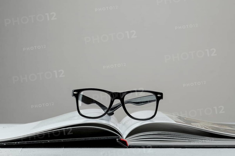 Front view open book with glasses
