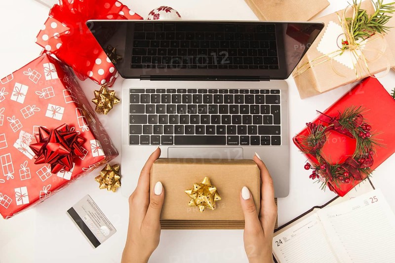 Woman holding gift box while shopping online table with christmas decoration. Resolution and high quality beautiful photo