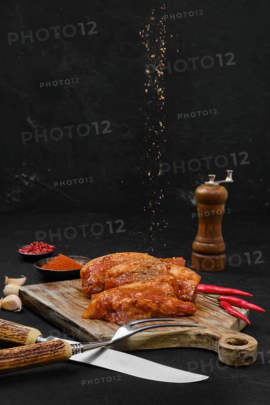 Pouring spice rub at marinated pork belly slice with spice ready for barbecue