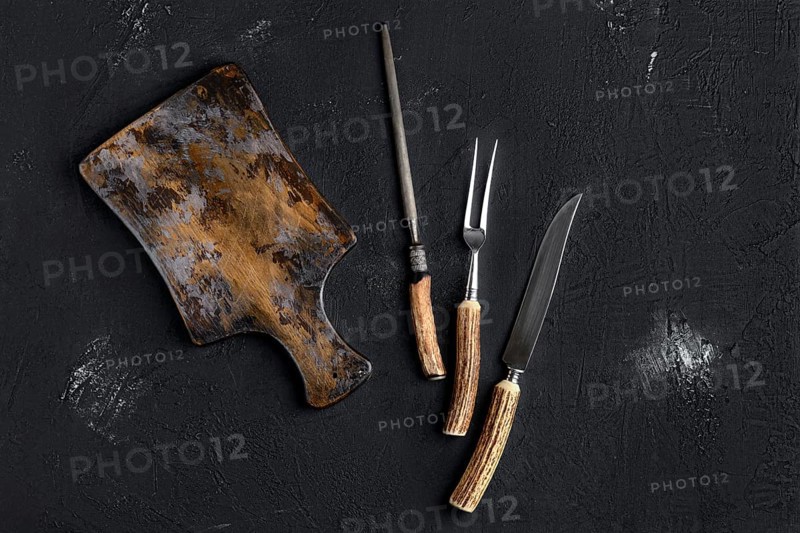 Rustic shabby cutting board with knife and fork for steak and knife sharpener