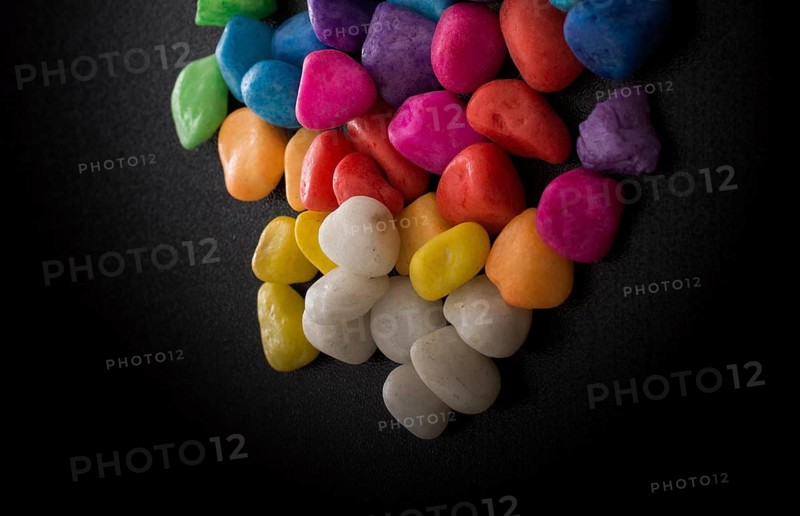 Pile of little colorful pebbles on black background