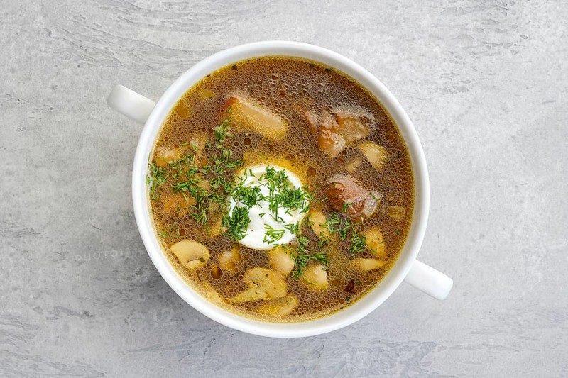 Top view of mushrooms and potato soup with sour cream