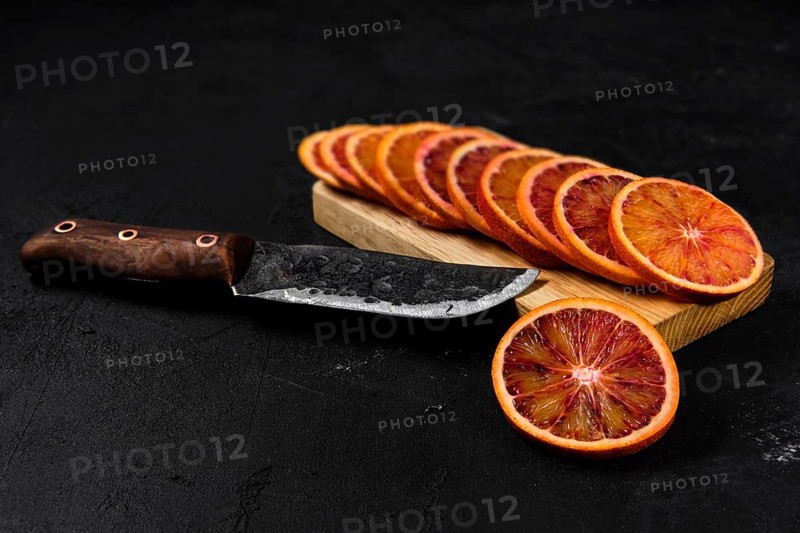 Overhead view of slices of blood orange on black background
