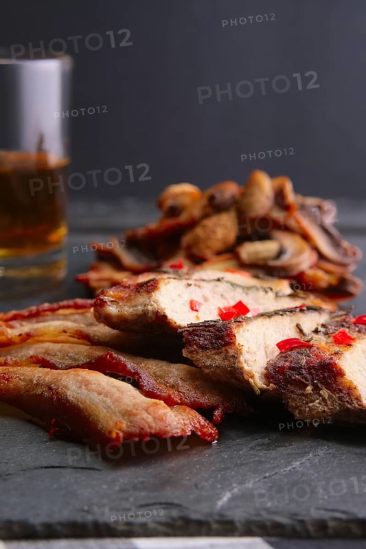 Soft focus photo of fried fillet with mushrooms and slices of bacon