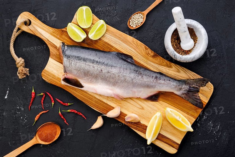 Top view of raw fresh headless pink salmon on wooden cutting board