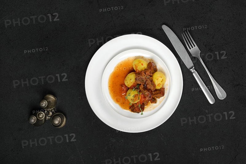 Overhead view of lamb stew with potato on a plate