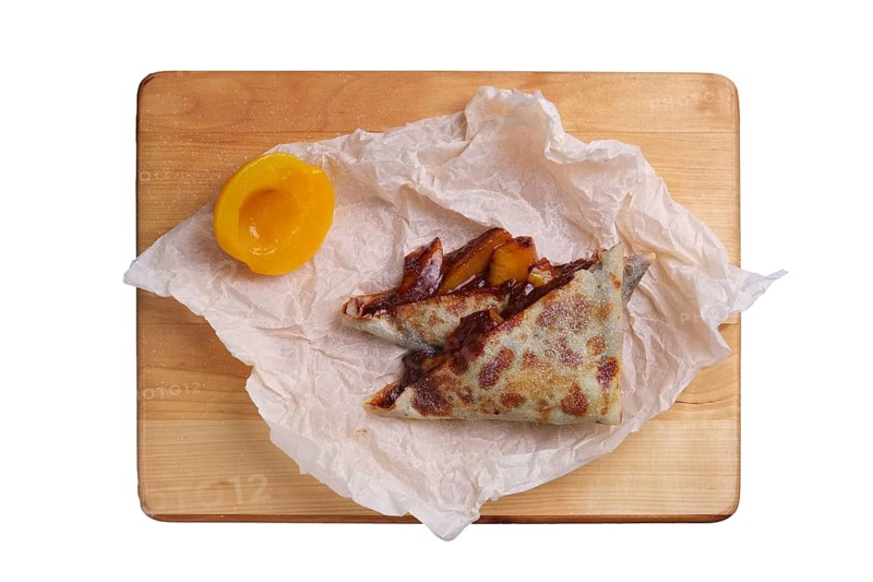 Thin pancakes stuffed with apricot and soft cheese isolated on white