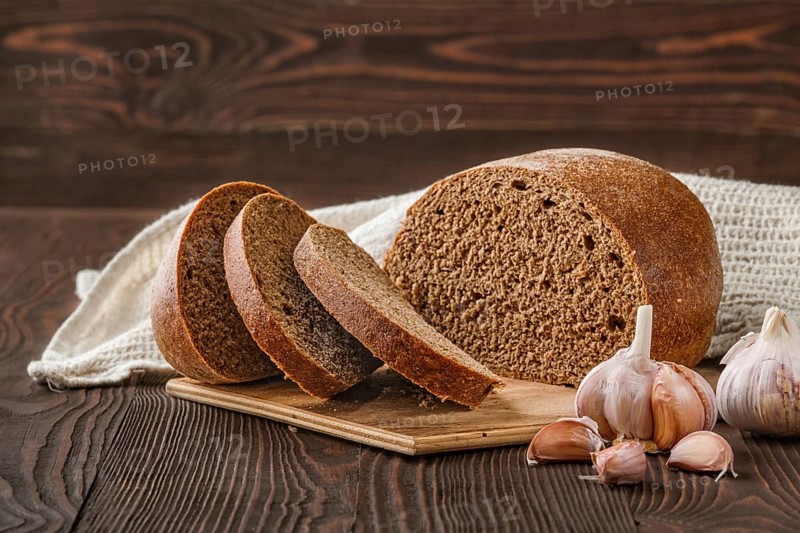 Brown garlic bread on cutting board on the table