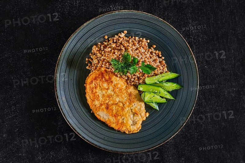 Chicken fillet fried in batter with buckwheat porridge and pickled cucumber