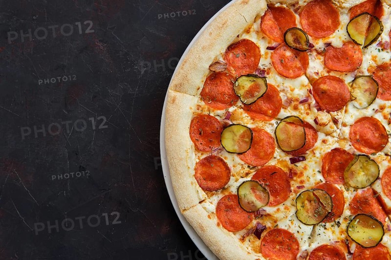 Top view of pizza with pickled cucumber and pepperoni sausage