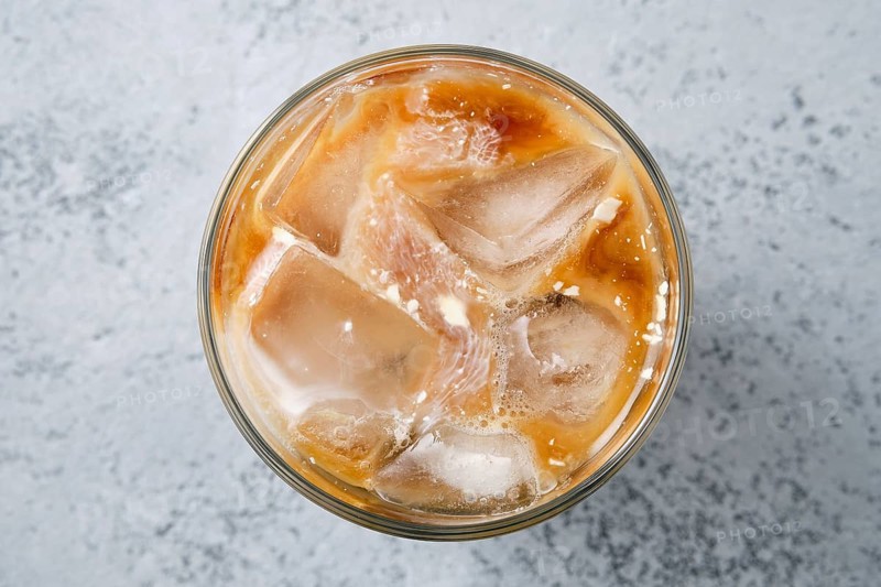 Top view of iced coffee with fat cream in rocks glass