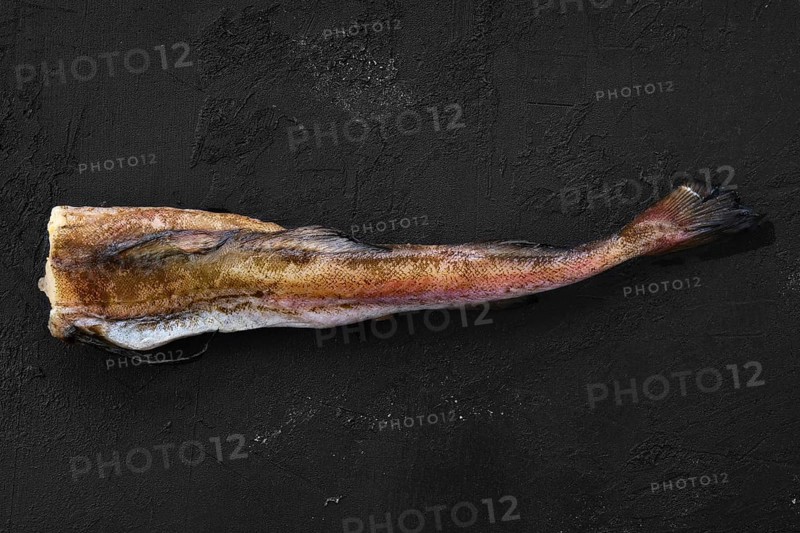 Frozen raw pollock carcass on wooden background