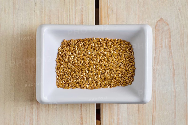 Top view of gold plated sesame seeds in cepamic bowl