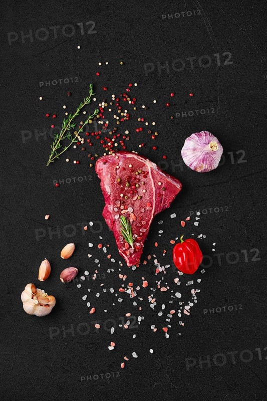 Overhead view of raw chuck eye steak with ingredients for cooking