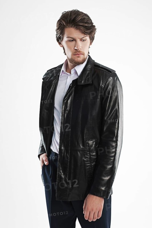Brutal handsome unshaven man with beard and moustache in waterproof coat with fur collar