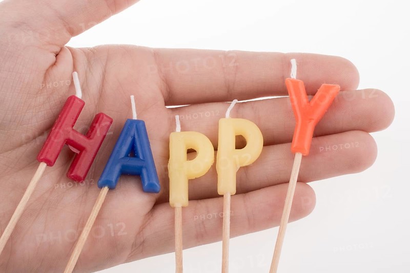 Color candles on sticks write the word happy