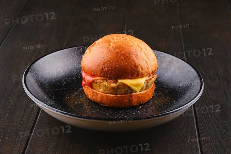 Simple burger with fish patty on wooden board