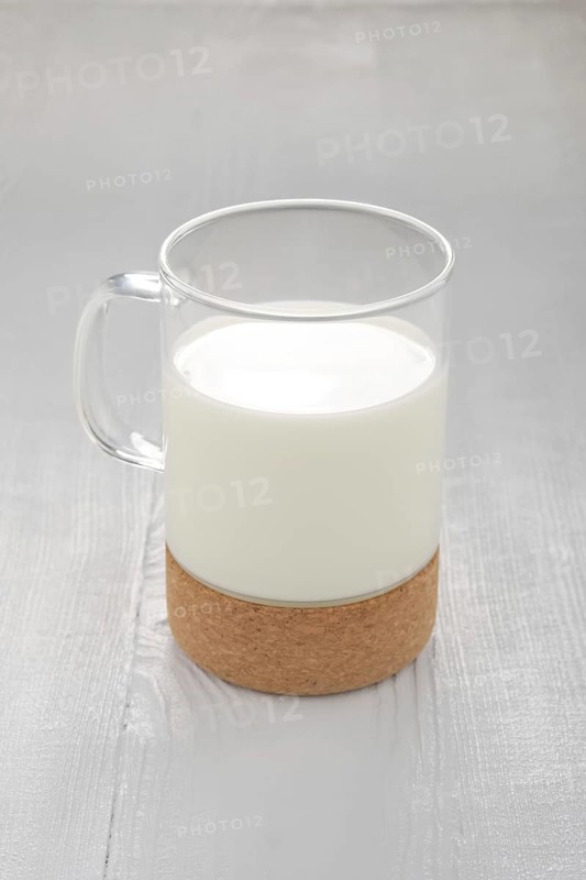 Glass of milk on white wooden kitchen table