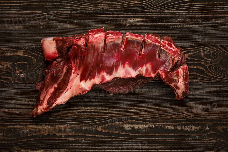 Overhead view of raw deer ribs over wooden background