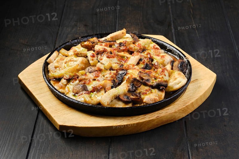 Slices of eggplant baked with champignon and cheese in cast iron skillet