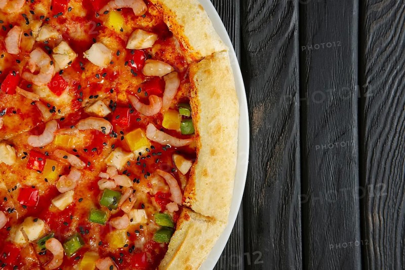 Top view of pizza with shrimps and chicken fillet