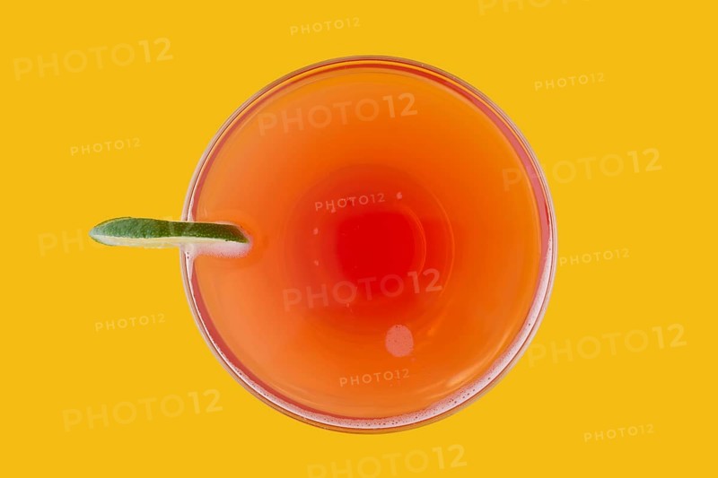 Top view of cosmopolitan cocktail on yellow background