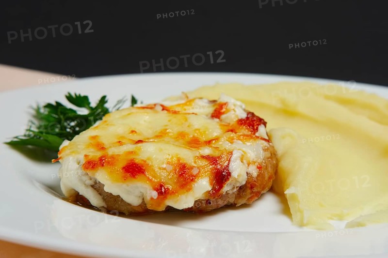 Meat cutlet with cheese and mashed potato. Closeup photo with selective focus