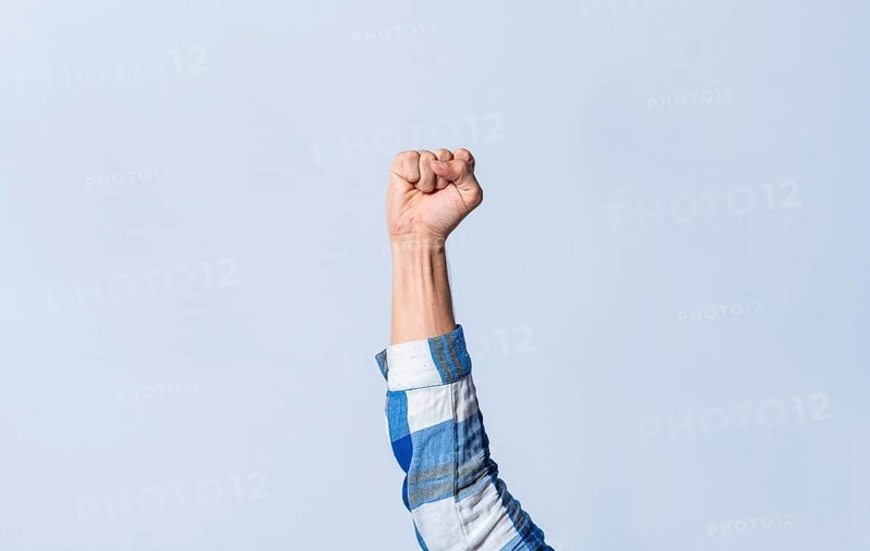 Hand gesturing the letter S in sign language on an isolated background. Man's hand gesturing the letter S of the alphabet isolated. Letter S of the alphabet in sign language