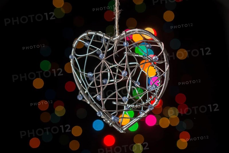 Heart shaped metal cage on a bokeh light background