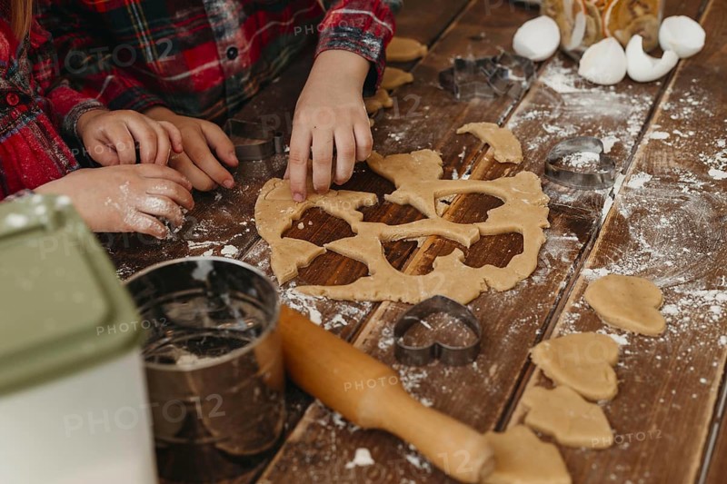High angle children making cookies together home