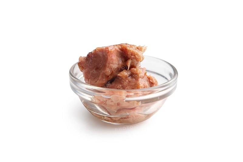 Canned tuna in transparent plate isolated on white