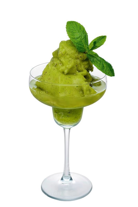 Kiwi smoothie in wide glass decorated with mint leaves isolated on white