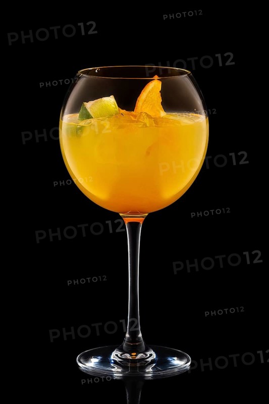 Big round wine glass with fresh cold lemonade isolated on black background