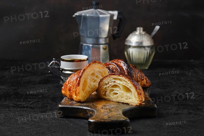 Classic breakfast with croissant cut on half and espresso coffee