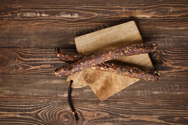 Sun dried turkey sausages on wooden background