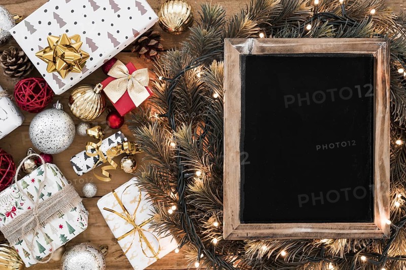 Photo frame fir twigs fairy lights near christmas decorations