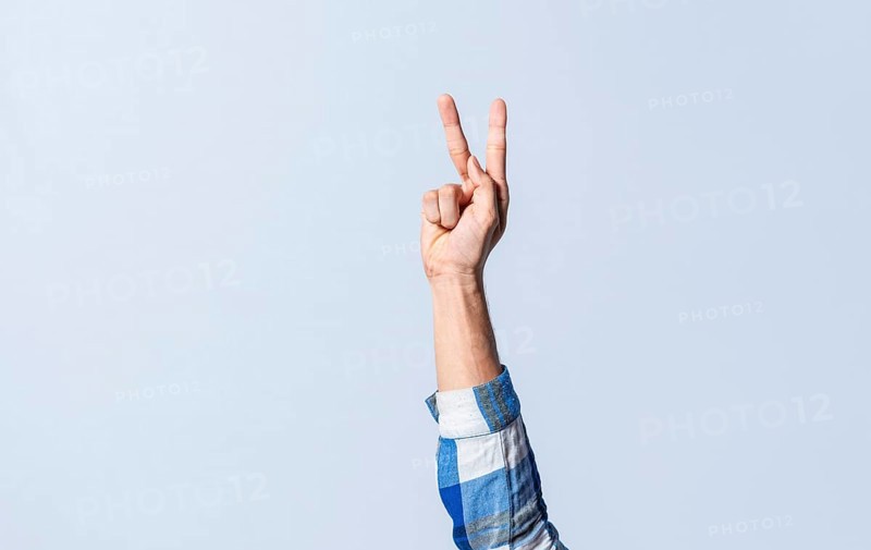 Hand gesturing the letter K in sign language on an isolated background. Man's hand gesturing the letter K of the alphabet isolated. Letters of the alphabet in sign language
