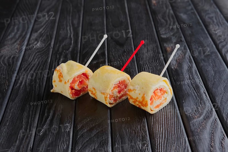 Appetizer for reception. Cutted pancake rolls with smoked salmon and caviar on skewer