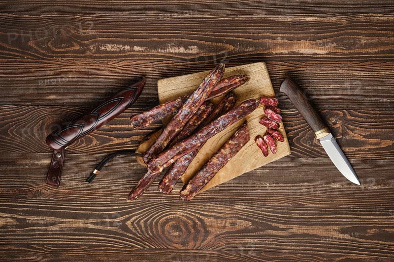 Air dried homemade beaver sausages on wooden background