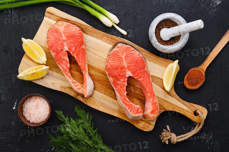 Raw fresh salmon steak on wooden cutting board
