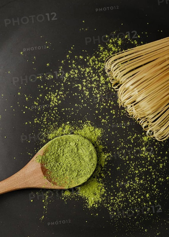 Close up matcha tea powder wooden spoon with bamboo whisk
