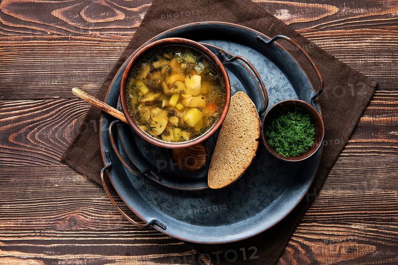 Overhead view of plate with champignon soup on wooden table