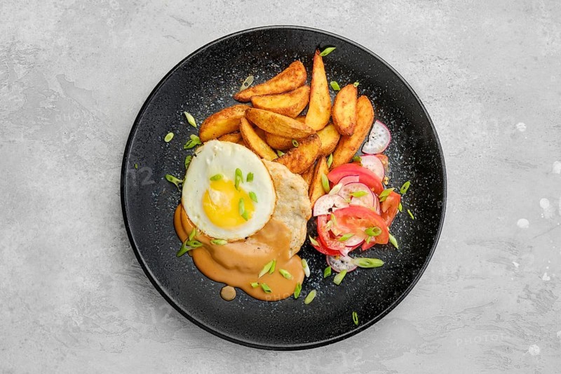 Top view of chopped pork sirloin with fried potato wedges