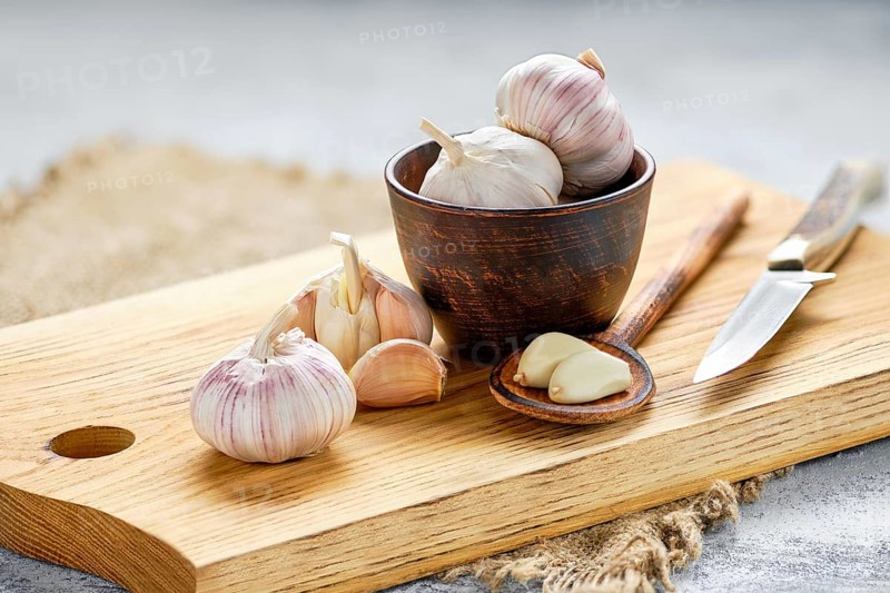 Garlic cloves and bulbs on wooden cutting board
