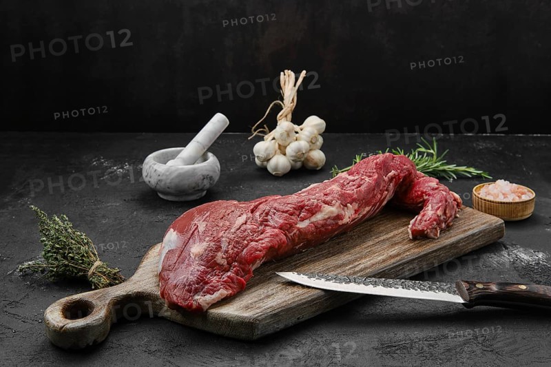Raw beef tri-tip loin on wooden cutting board