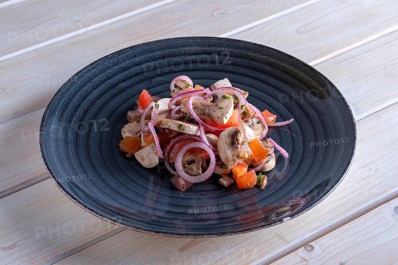 Lightly fried champignon with fresh onion rings and tomato. Snack for drink