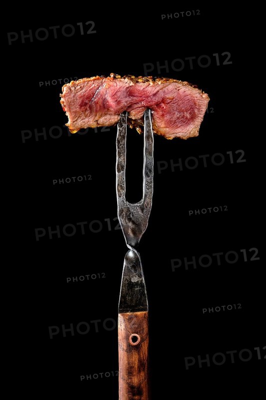 Piece of medium rare steak on the fork