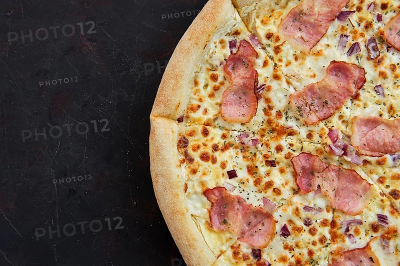 Close up view of pizza carbonara with bacon and onion